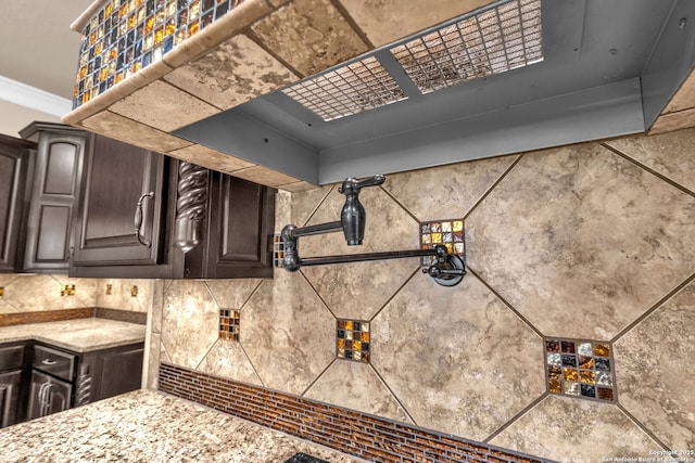 interior details featuring dark brown cabinetry and light stone countertops