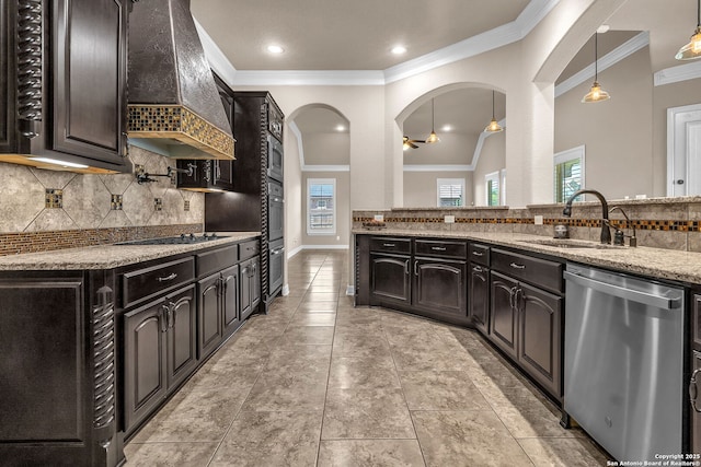kitchen with tasteful backsplash, premium range hood, appliances with stainless steel finishes, and a sink