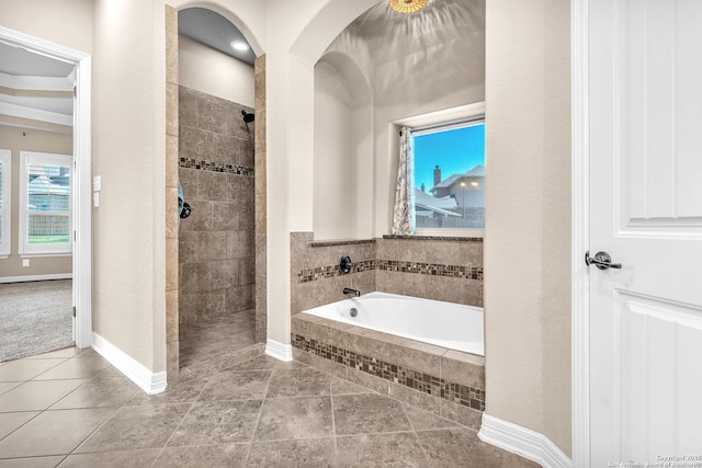 full bathroom with baseboards, tile patterned flooring, walk in shower, and a garden tub