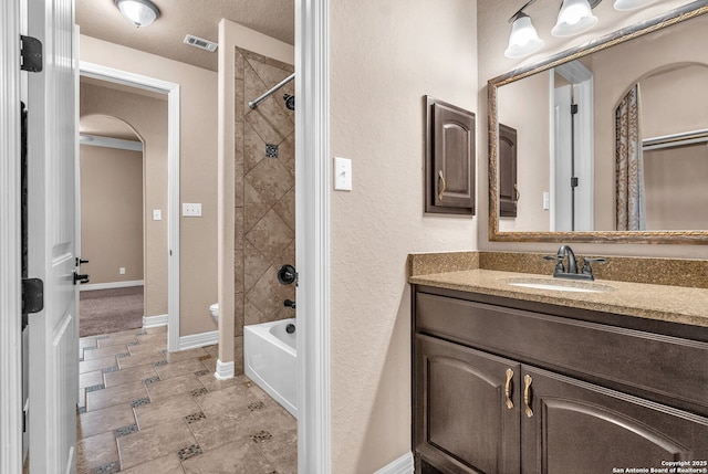 full bathroom with vanity, bathing tub / shower combination, toilet, visible vents, and baseboards