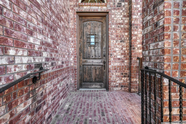 view of exterior entry with brick siding