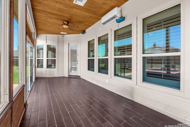 unfurnished sunroom featuring a ceiling fan and a wall mounted AC