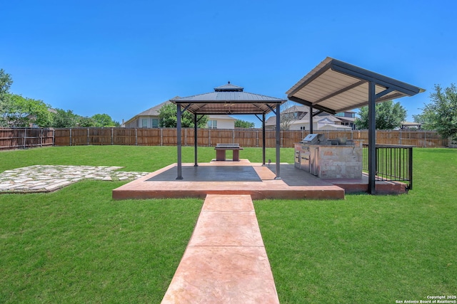 view of yard featuring an outdoor kitchen, a gazebo, a fenced backyard, and a patio area