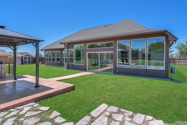 back of property featuring an outdoor structure, a patio area, a shed, fence, and a yard