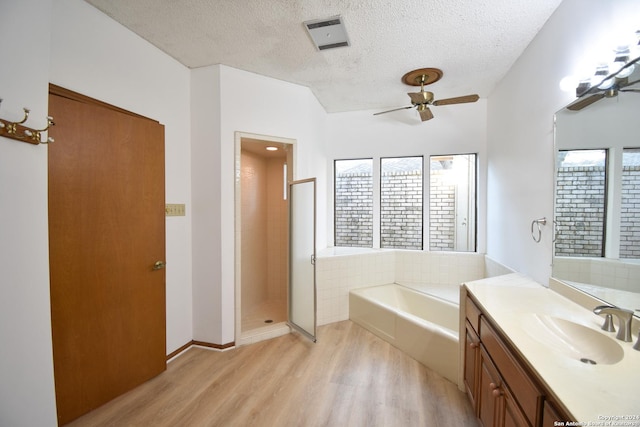 15019 Churchill Ests, San Antonio, TX 78248 - full bathroom featuring wood finished floors, a garden tub, ceiling fan, visible vents, and a textured ceiling