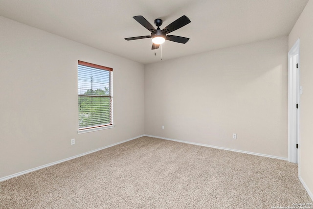 carpeted empty room featuring baseboards and a ceiling fan