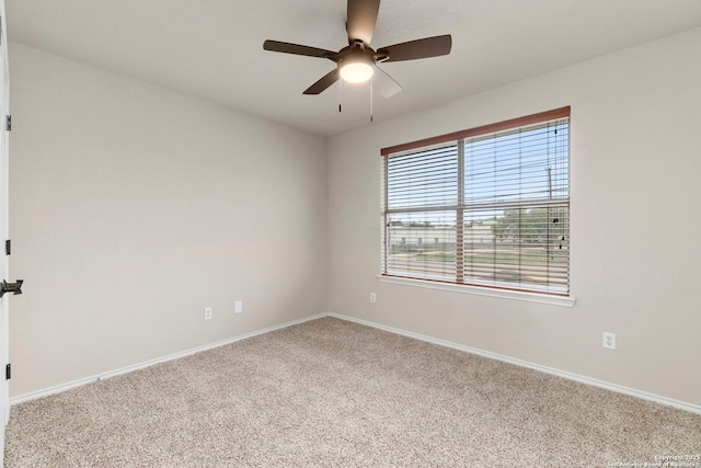 carpeted empty room with baseboards and a ceiling fan