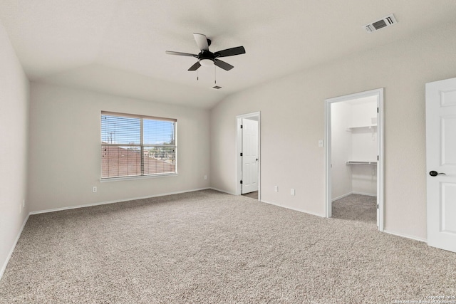 unfurnished bedroom with carpet floors, baseboards, a walk in closet, and visible vents