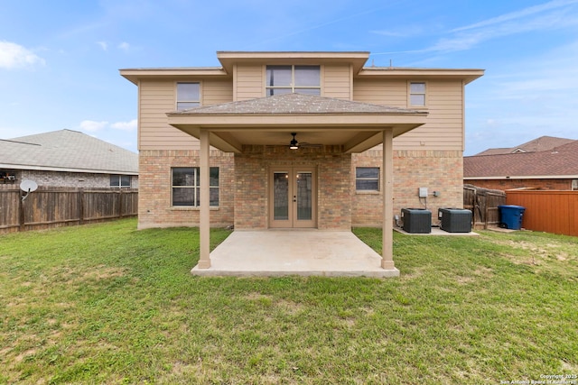rear view of house with brick siding, a ceiling fan, a fenced backyard, and central AC unit
