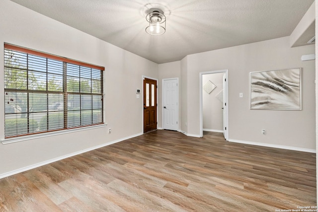 foyer entrance featuring baseboards and wood finished floors