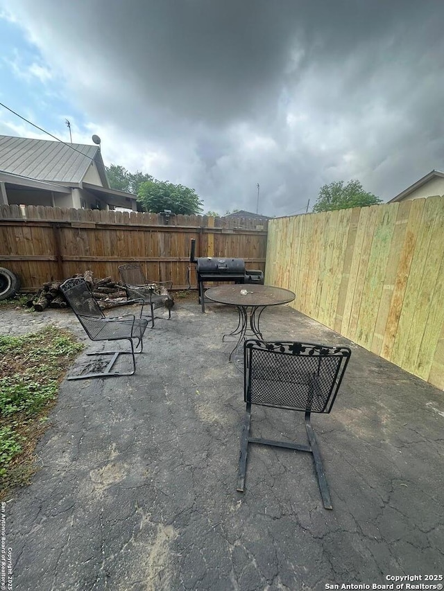 view of patio / terrace with fence and a grill