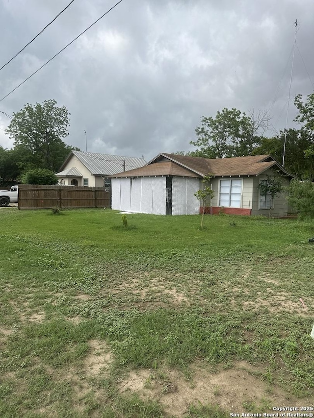exterior space featuring a lawn and fence