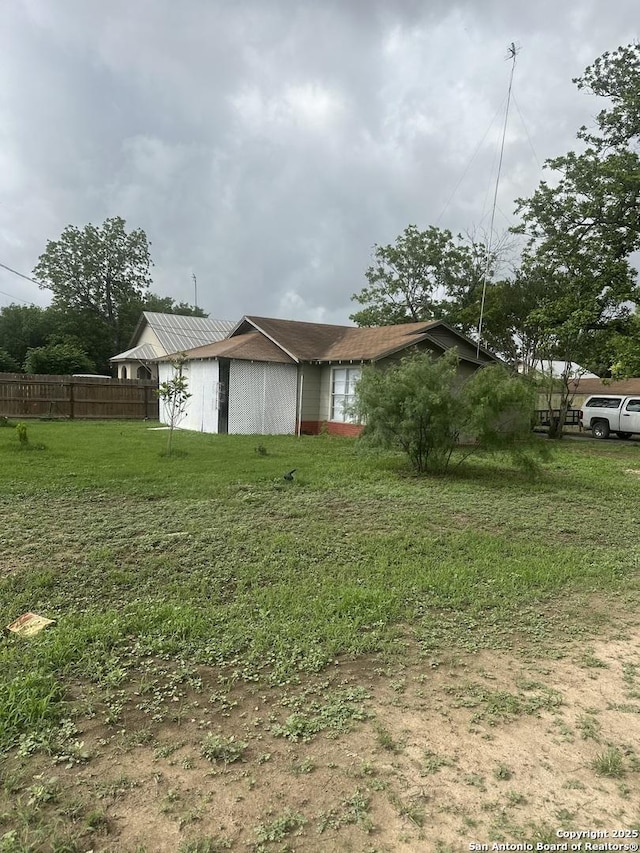 view of home's exterior featuring fence and a yard