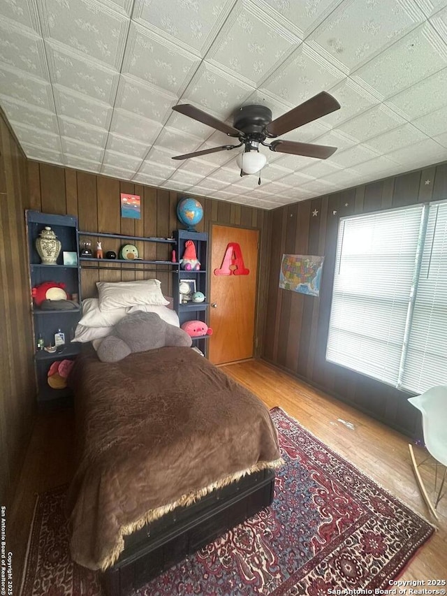 bedroom featuring wood walls and wood finished floors