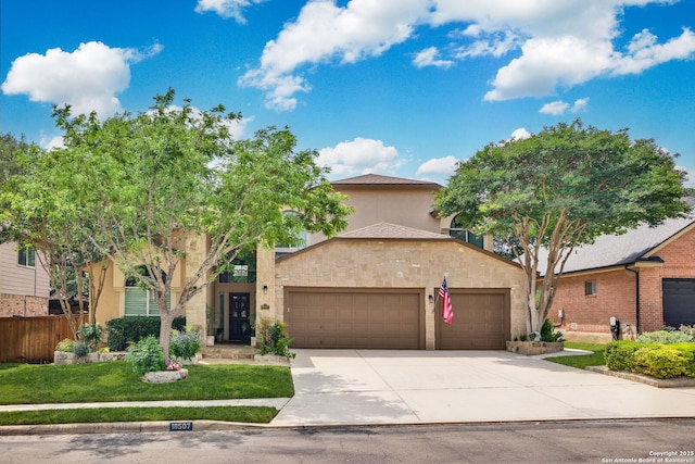 view of front of house featuring stucco siding, fence, concrete driveway, and a garage