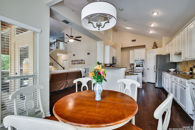 dining area with visible vents, high vaulted ceiling, stairway, dark wood-type flooring, and a ceiling fan