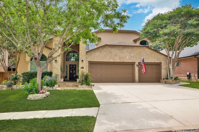 mediterranean / spanish-style house featuring an attached garage, stone siding, driveway, and a front yard