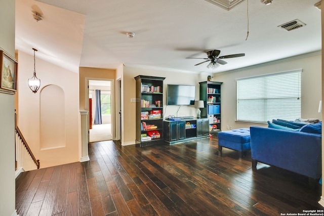 living room with attic access, a ceiling fan, dark wood-type flooring, visible vents, and ornamental molding