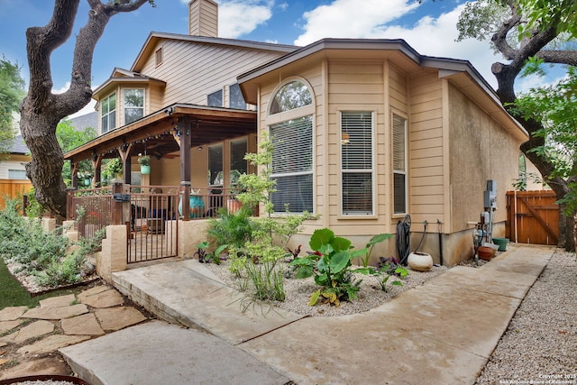 view of front of home featuring fence private yard, a chimney, and a gate