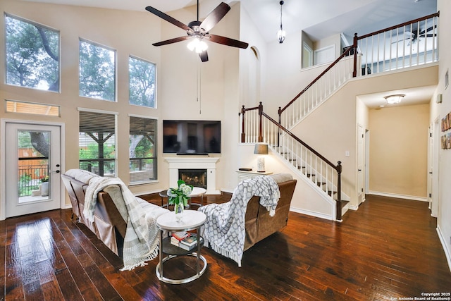 living room with a ceiling fan, hardwood / wood-style floors, and high vaulted ceiling