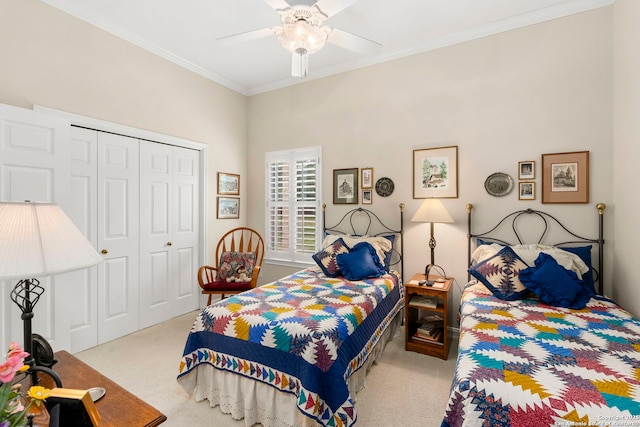 carpeted bedroom featuring a ceiling fan, ornamental molding, and a closet