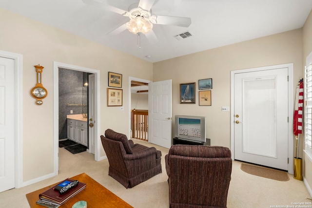 living area with visible vents, ceiling fan, baseboards, and light carpet