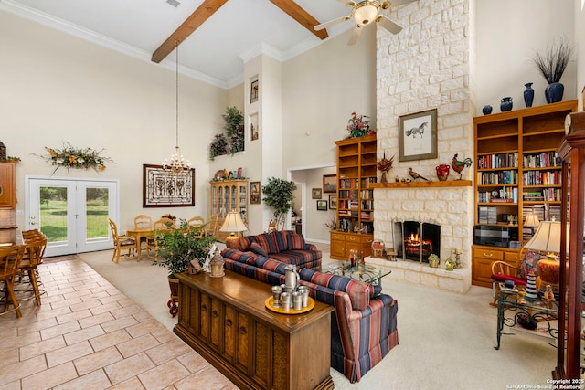 living room with ceiling fan with notable chandelier, a stone fireplace, carpet flooring, beam ceiling, and high vaulted ceiling
