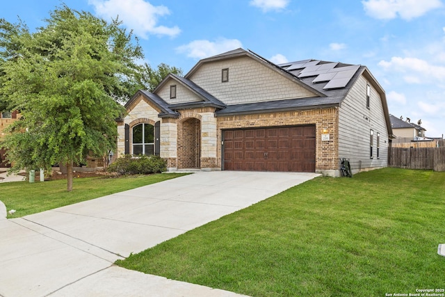 view of front of home featuring fence, a garage, solar panels, a front lawn, and concrete driveway