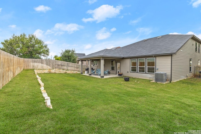 rear view of property featuring a patio, a fenced backyard, central AC, and a lawn