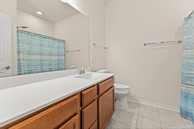 bathroom featuring toilet, vanity, tile patterned flooring, and baseboards
