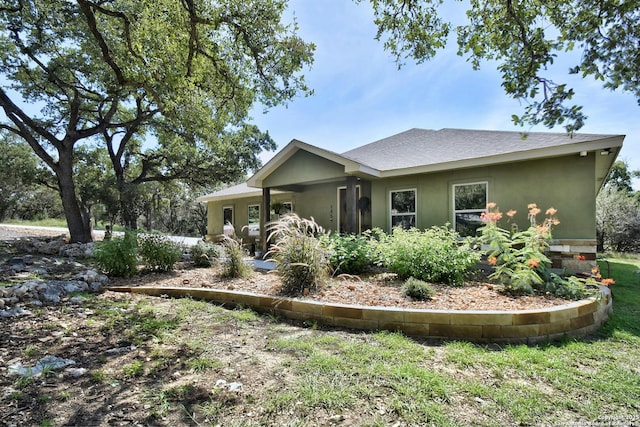 exterior space featuring a shingled roof and stucco siding