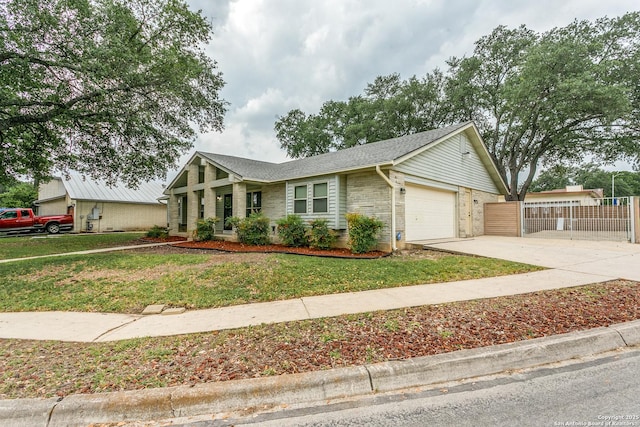 ranch-style home featuring a front lawn, driveway, brick siding, an attached garage, and fence