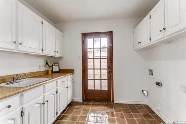 washroom featuring hookup for a washing machine, cabinet space, gas dryer hookup, a sink, and baseboards