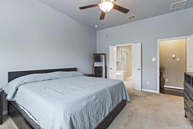 carpeted bedroom with visible vents, ceiling fan, ensuite bath, and baseboards