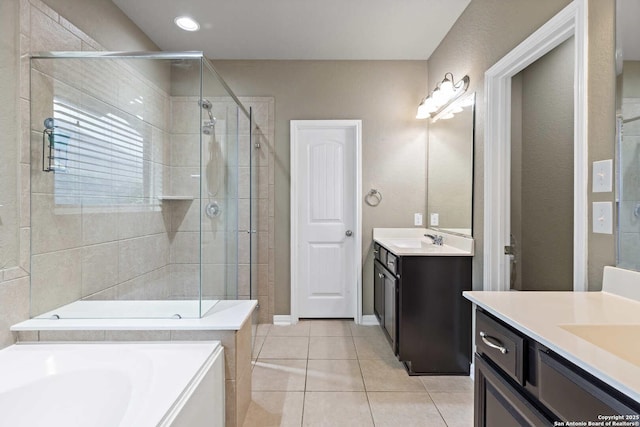 bathroom featuring a sink, a shower stall, two vanities, a garden tub, and tile patterned flooring