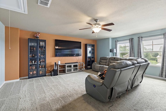 living room featuring a textured ceiling, carpet flooring, visible vents, ceiling fan, and baseboards