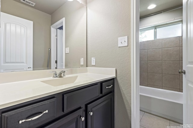 bathroom featuring visible vents, a textured wall, shower / bathing tub combination, vanity, and tile patterned flooring