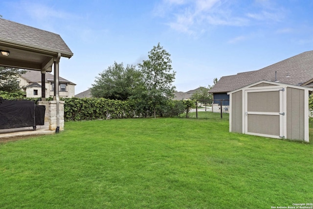 view of yard with an outdoor structure, a storage shed, and fence