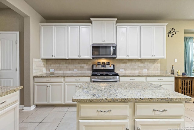 kitchen featuring light tile patterned floors, appliances with stainless steel finishes, and decorative backsplash