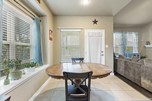 dining space featuring light tile patterned floors, plenty of natural light, and baseboards