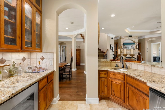 bar with backsplash, a sink, crown molding, and wine cooler