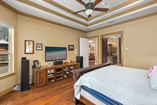 bedroom featuring a tray ceiling, visible vents, ornamental molding, arched walkways, and hardwood / wood-style floors