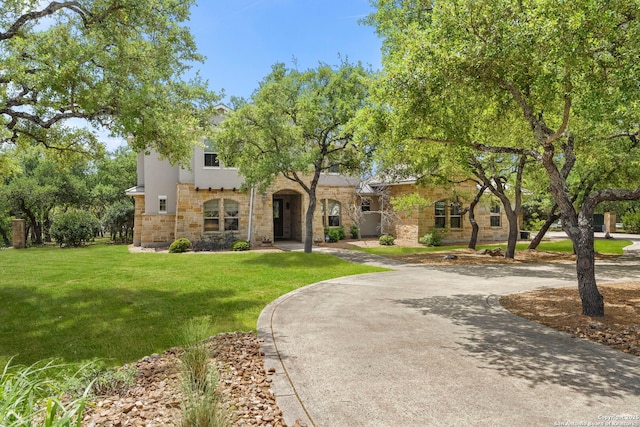 view of front of home with a front yard and stone siding