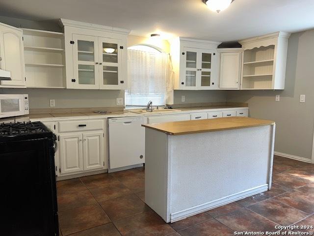 116 N Matlock, Poth, TX 78147 - kitchen featuring white appliances, glass insert cabinets, open shelves, light countertops, and a sink