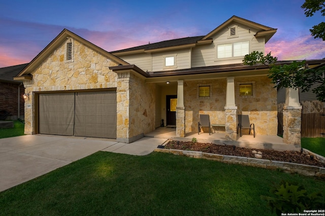traditional-style home with driveway, stone siding, a lawn, a porch, and a garage