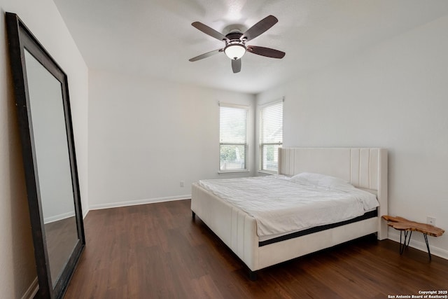 bedroom with dark wood-style flooring, ceiling fan, and baseboards