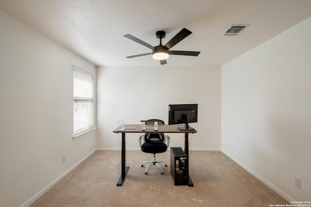 carpeted home office featuring baseboards, visible vents, and a ceiling fan