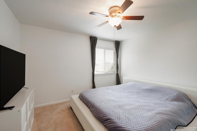 bedroom with a ceiling fan, light colored carpet, and baseboards