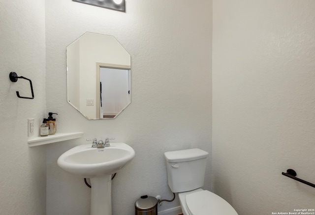 half bathroom featuring toilet and a sink