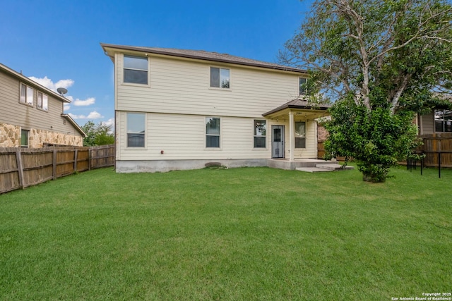 rear view of property featuring a lawn and a fenced backyard